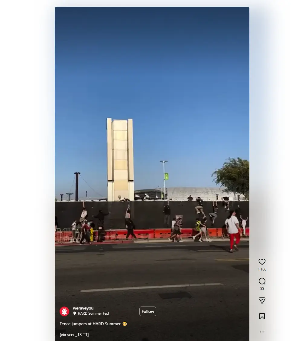 Still image from a video recording people climbing over a tall fence to breach an event taking place in a city