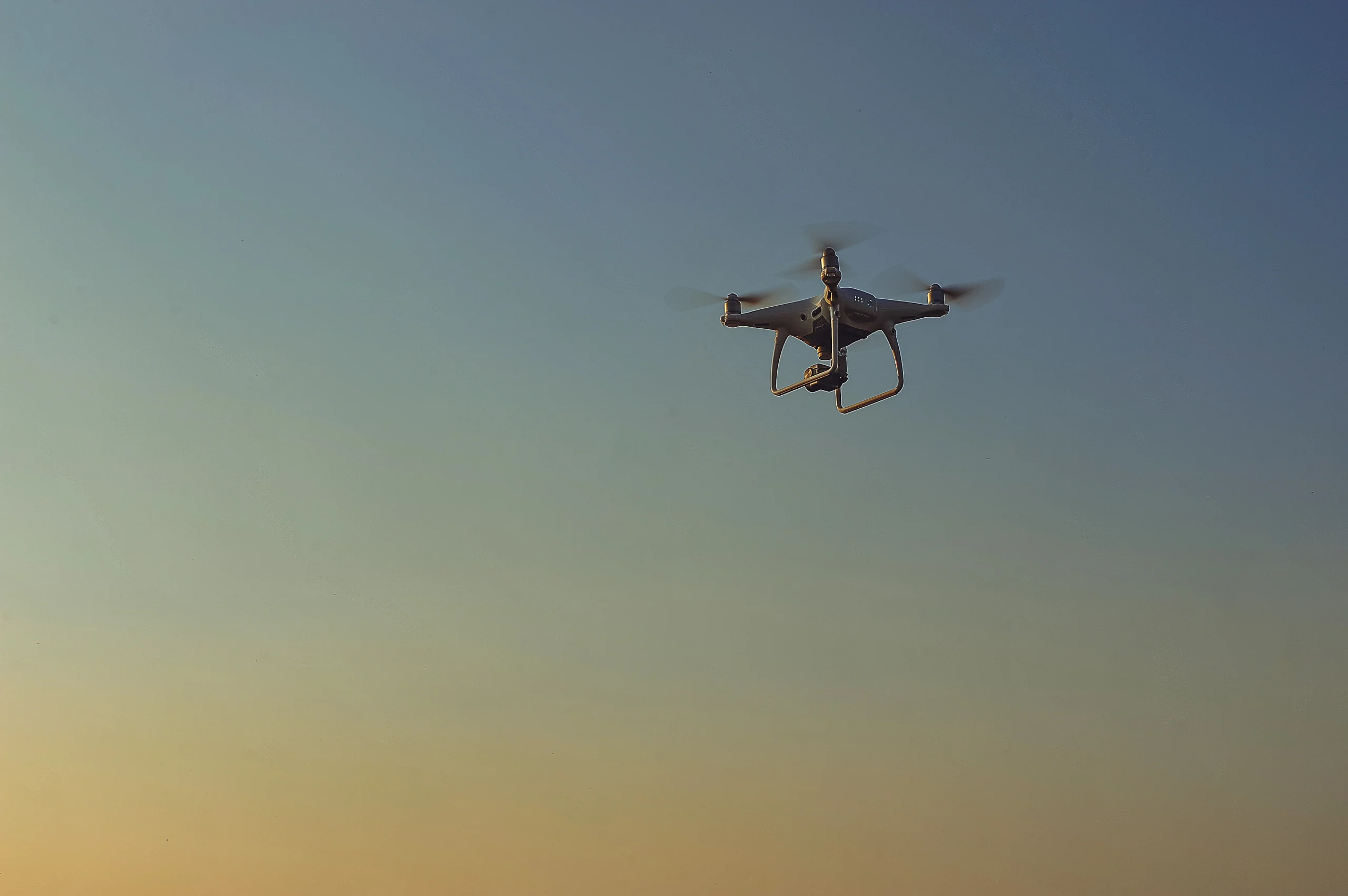 Distant security drone flying high in the blue sky during thr morning 